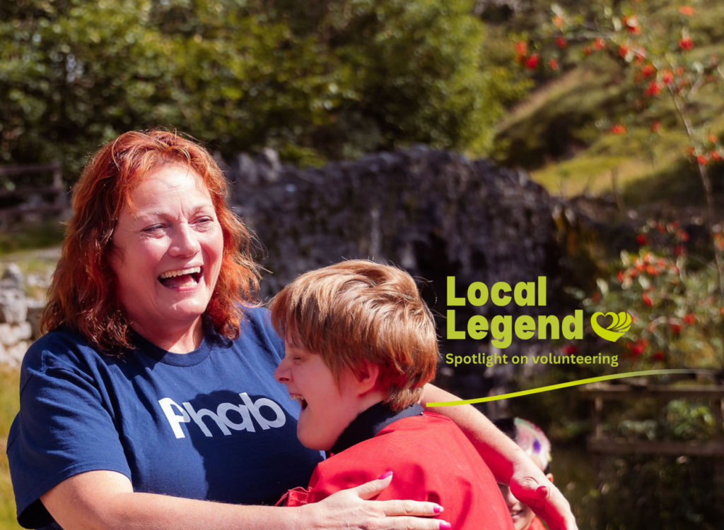 A woman in a Phab t-shirt hugs a boy. There is a Local Legends logo
