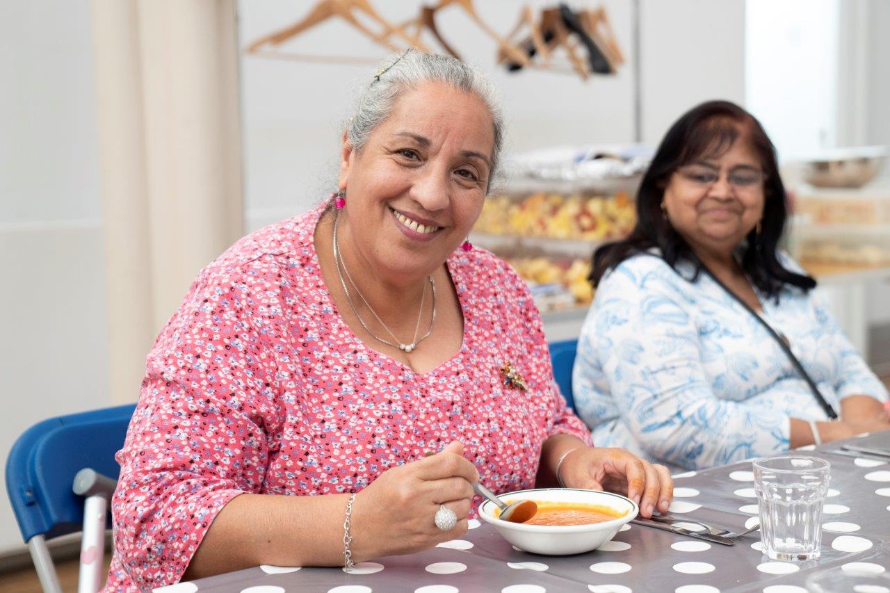 Two women eat a meal at FoodCycle