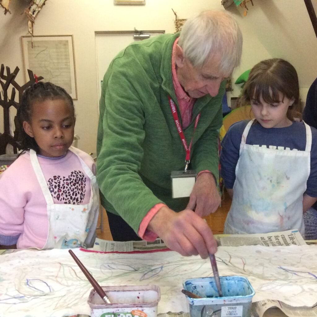 Two children and a man paint