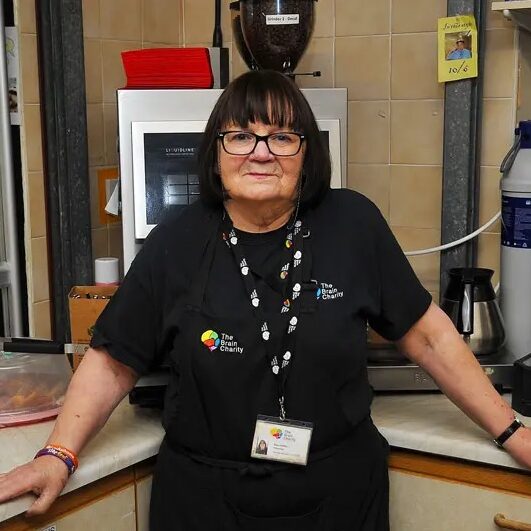 A woman in black in the brain charity cafe