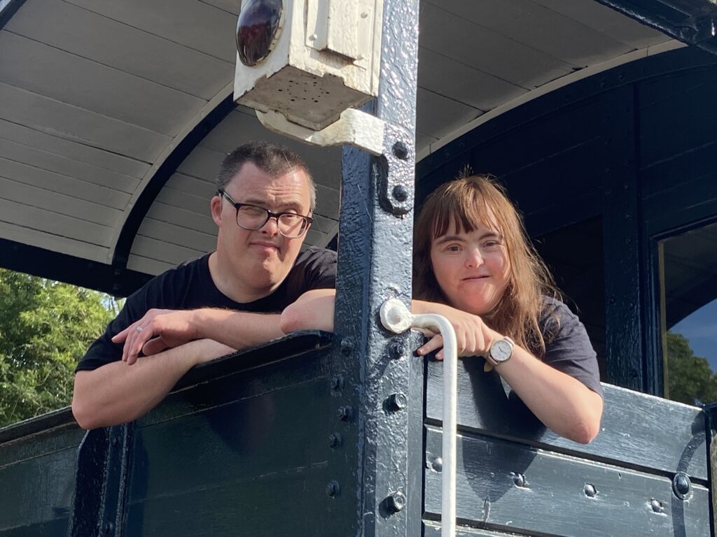 A young man and young woman stand on a railway signalling platform