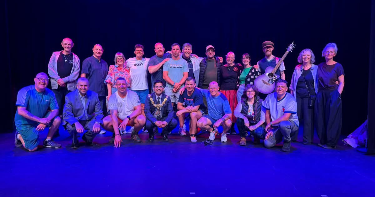 A group of men on a stag in a blue light.