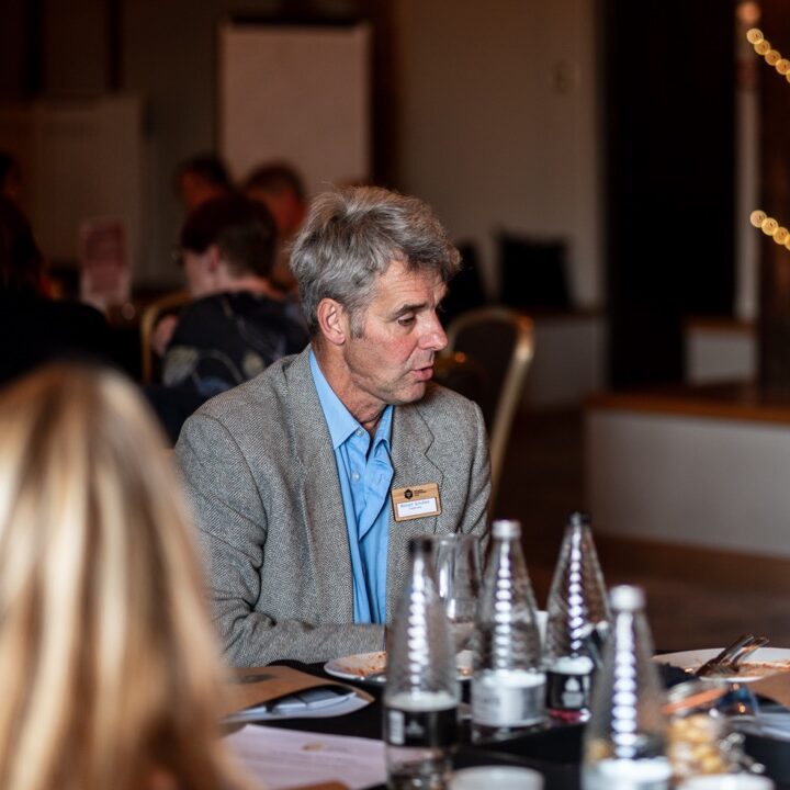 A man chats on a table at a conference